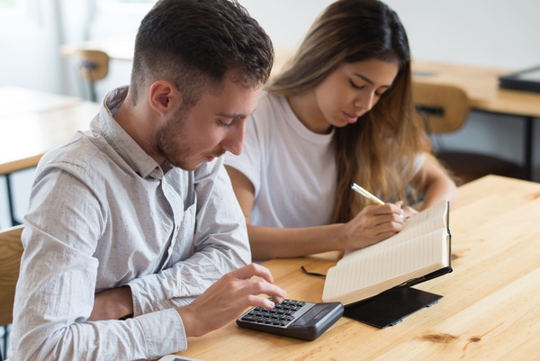 focused-students-using-calculator-studying-together (1) (1)
