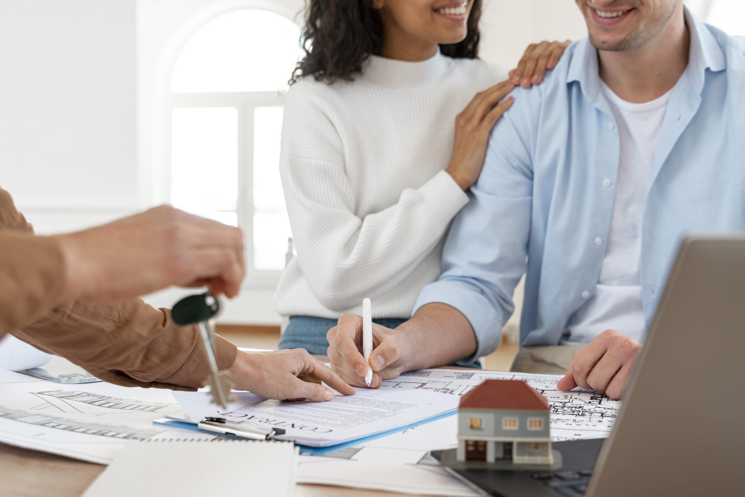 smiley-couple-signing-contract-new-house (1)